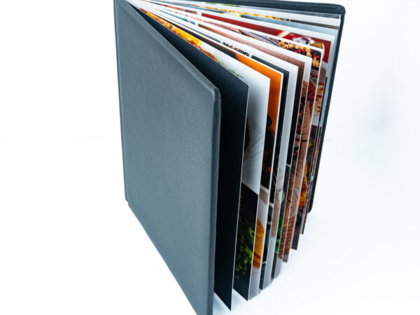 Photo of a photo album with multiple pages of colourful images.