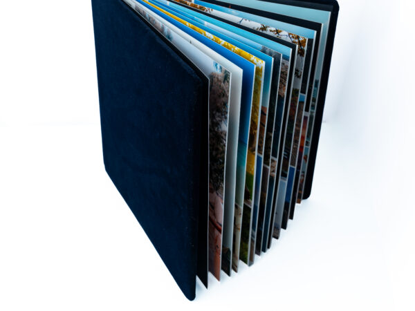 Photo album with multiple pages of photographs in a blue cover.