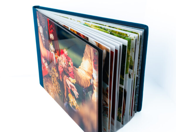 Photo album with colorful photographs and a blue cover on a white background.