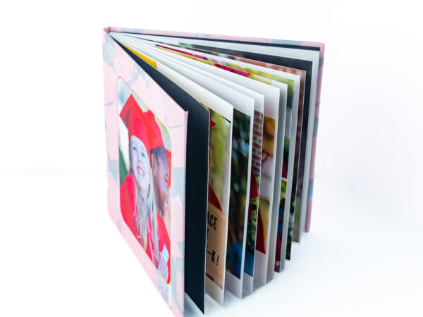 Colorful photo album with various pictures and a girl in a red hat on the cover.